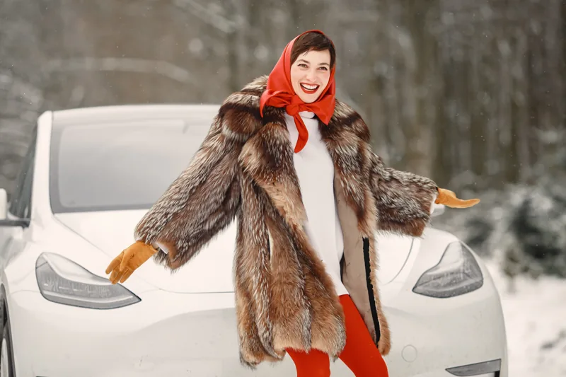 Woman beside a parked car in a snowy setting